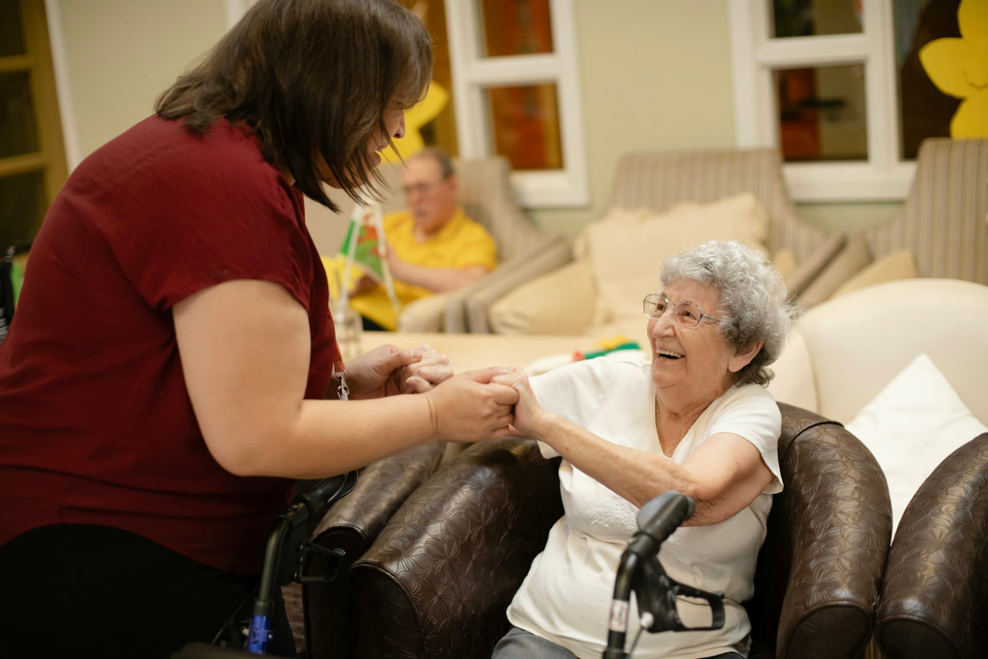 Caregiver assisting elderly woman with walker at home